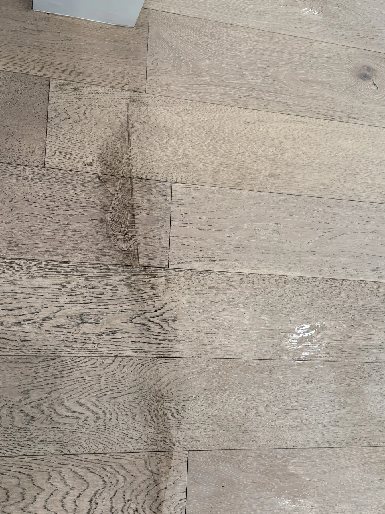 Ground-in soil and residue across finished hardwood boards