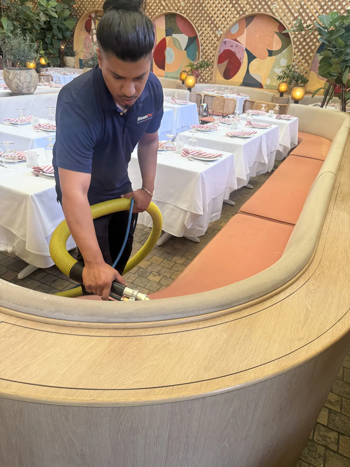 Curved upholstered banquette receiving professional extraction cleaning